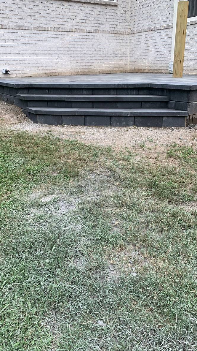 Charcoal paver landing beside white brick.